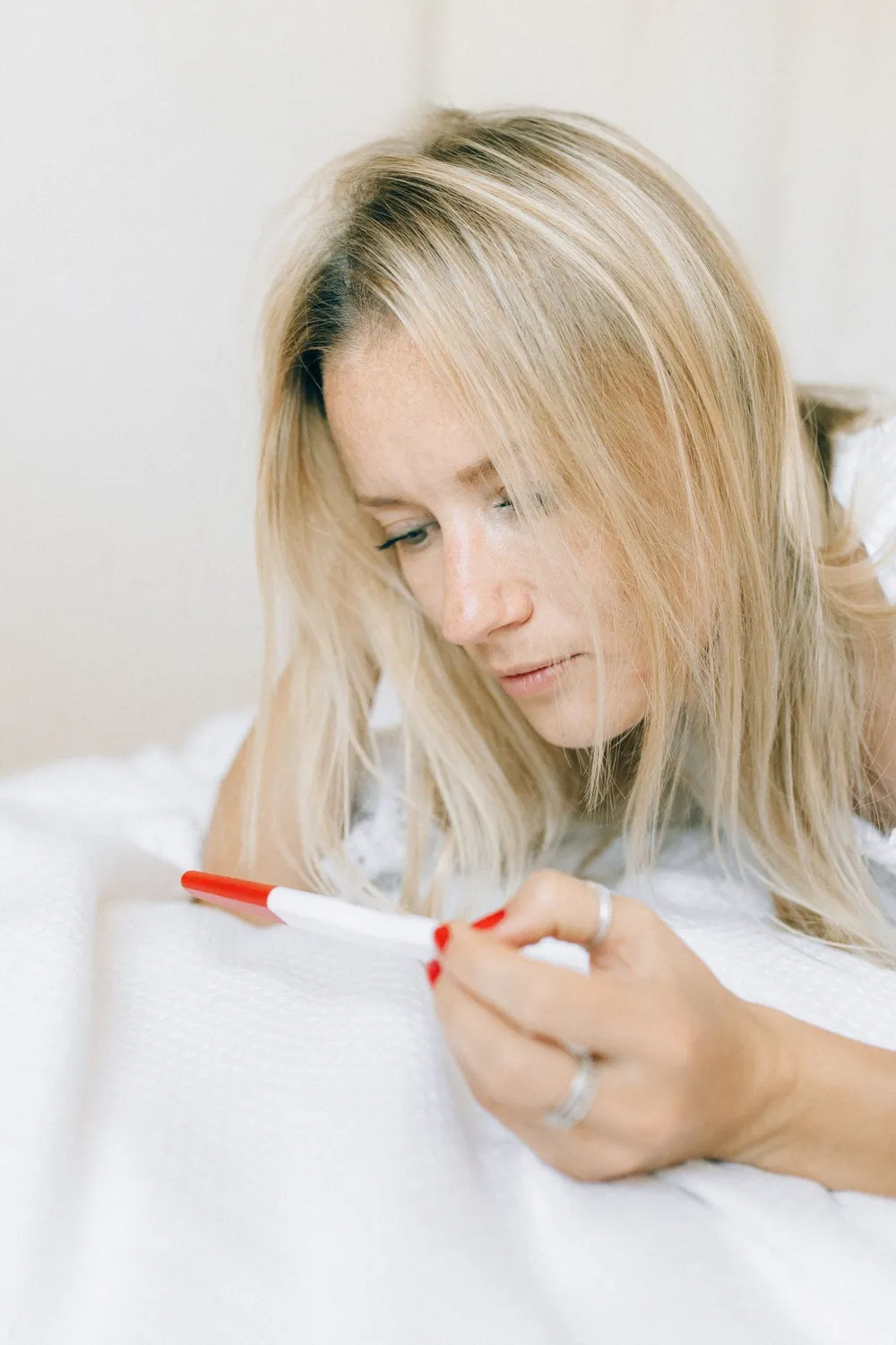 Woman looking thoughtfully at a pregnancy test