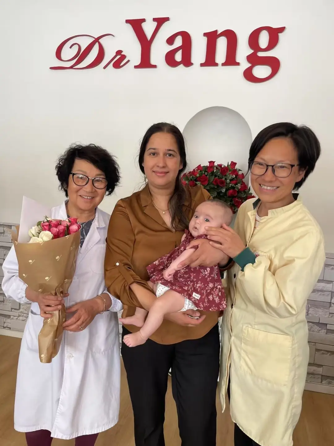 Dr Yang och Jihua med en glad patient och baby på kliniken